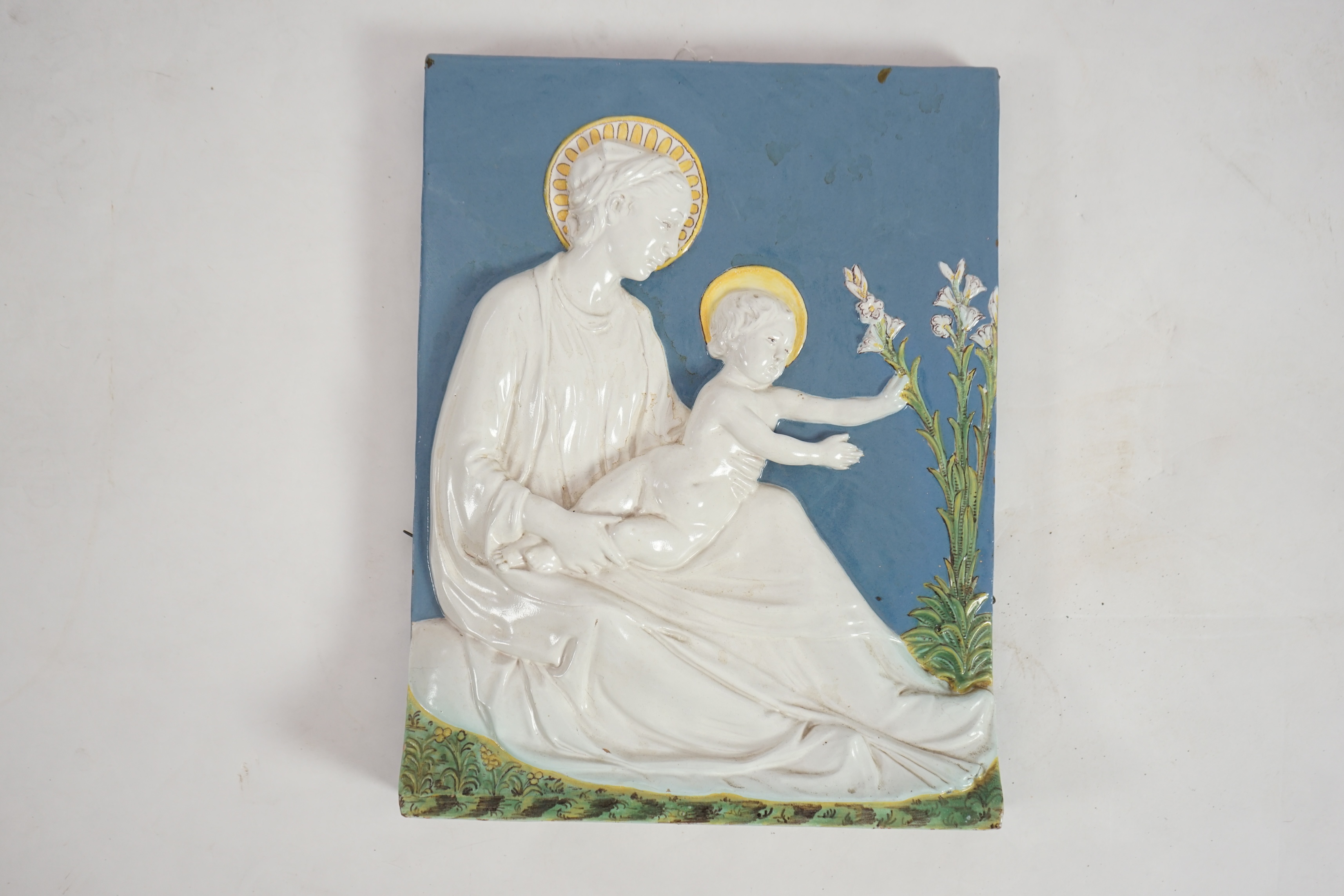 A Cantagalli maiolica wall plaque depicting the Virgin and child, 19th century, after Della Robbia, initialled verso EvH 329, 33cm wide, 43cm high. Condition - fair to good